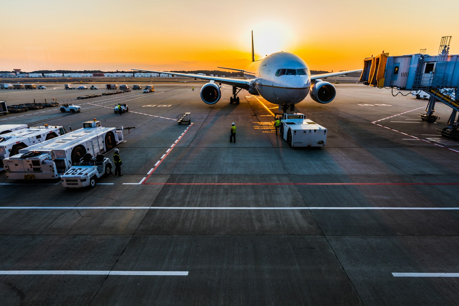 Wide-body airplane at a gate during sunset